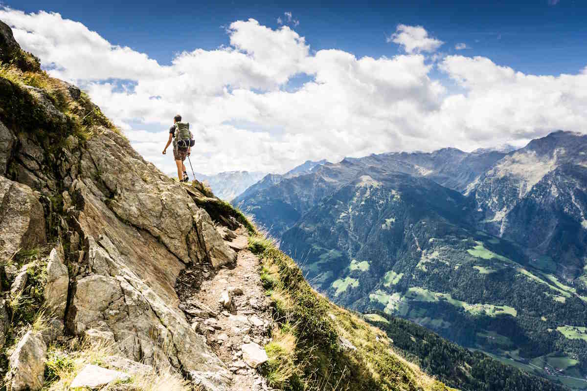 Person climbing a mountain along a rocky trail