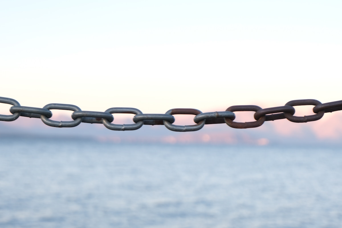 A chain link in front of a body of water