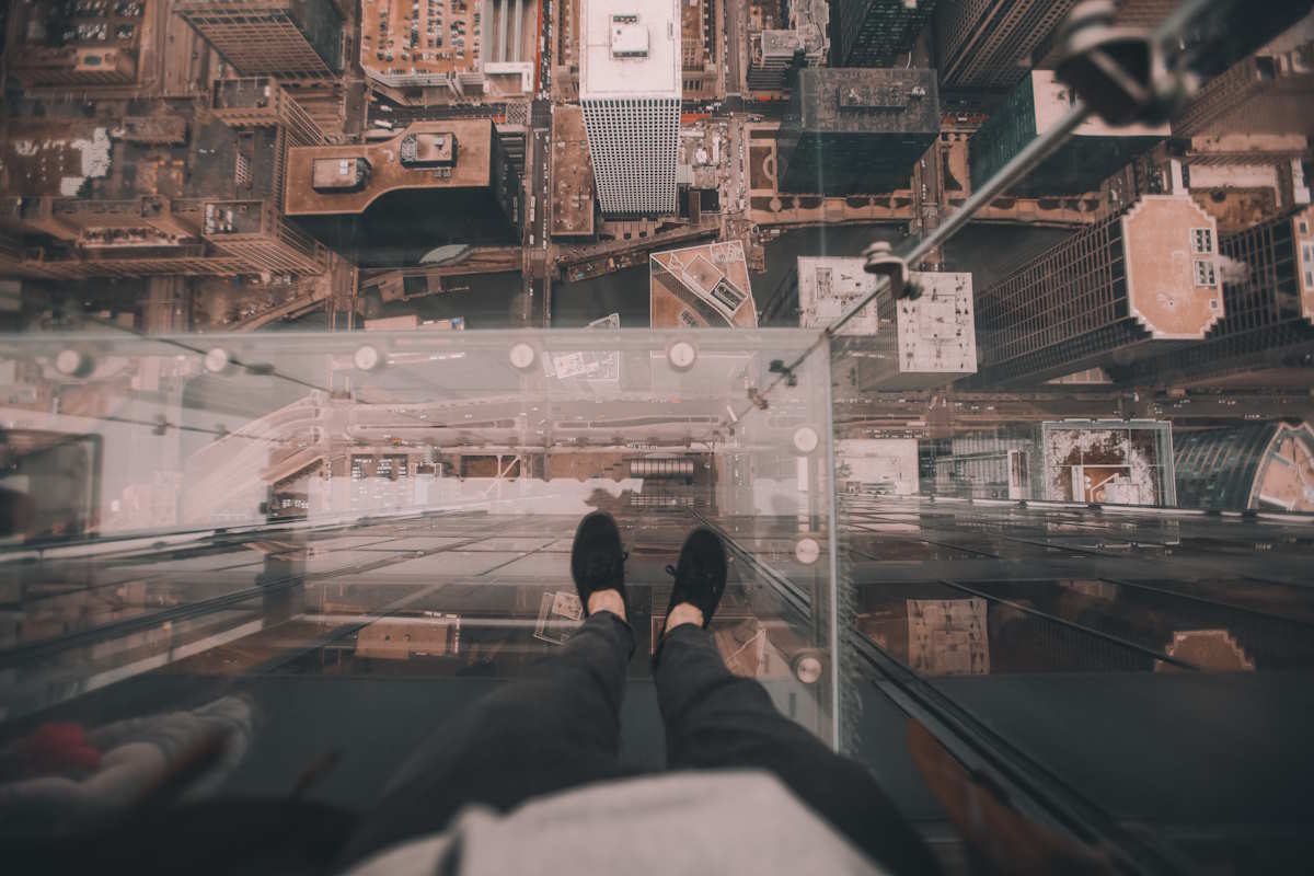 Person stood on glass platform looking down at the city below