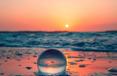 A glass ball on a beach at sunrise