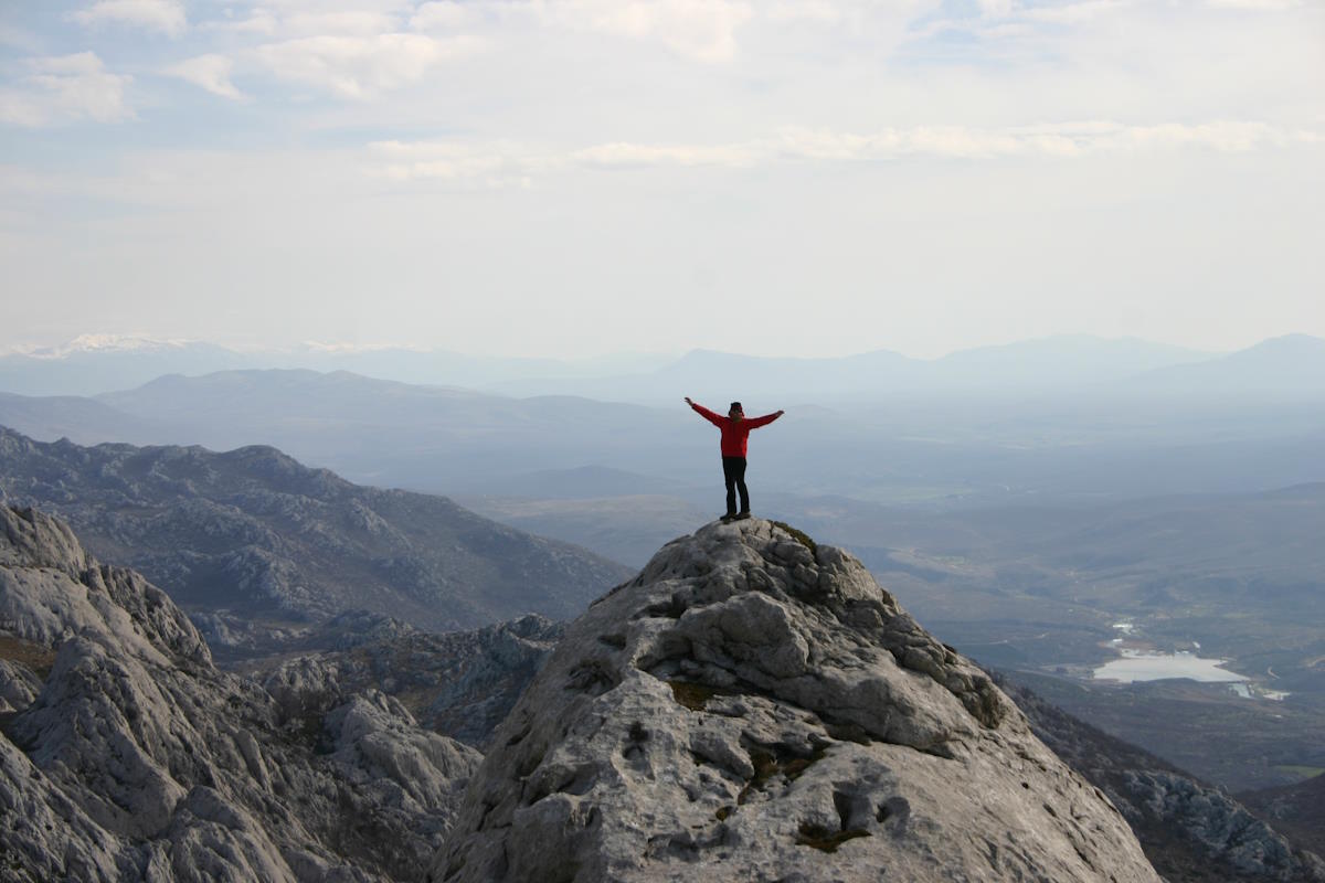 Person stood on top of a mountain peak