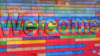 A wooden sign reading 'Welcome' painted in many colours