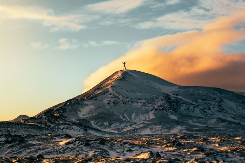 Person stood on top of mountain during daytime