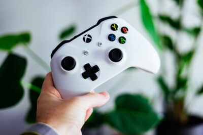 A person's hand holding an Xbox controller