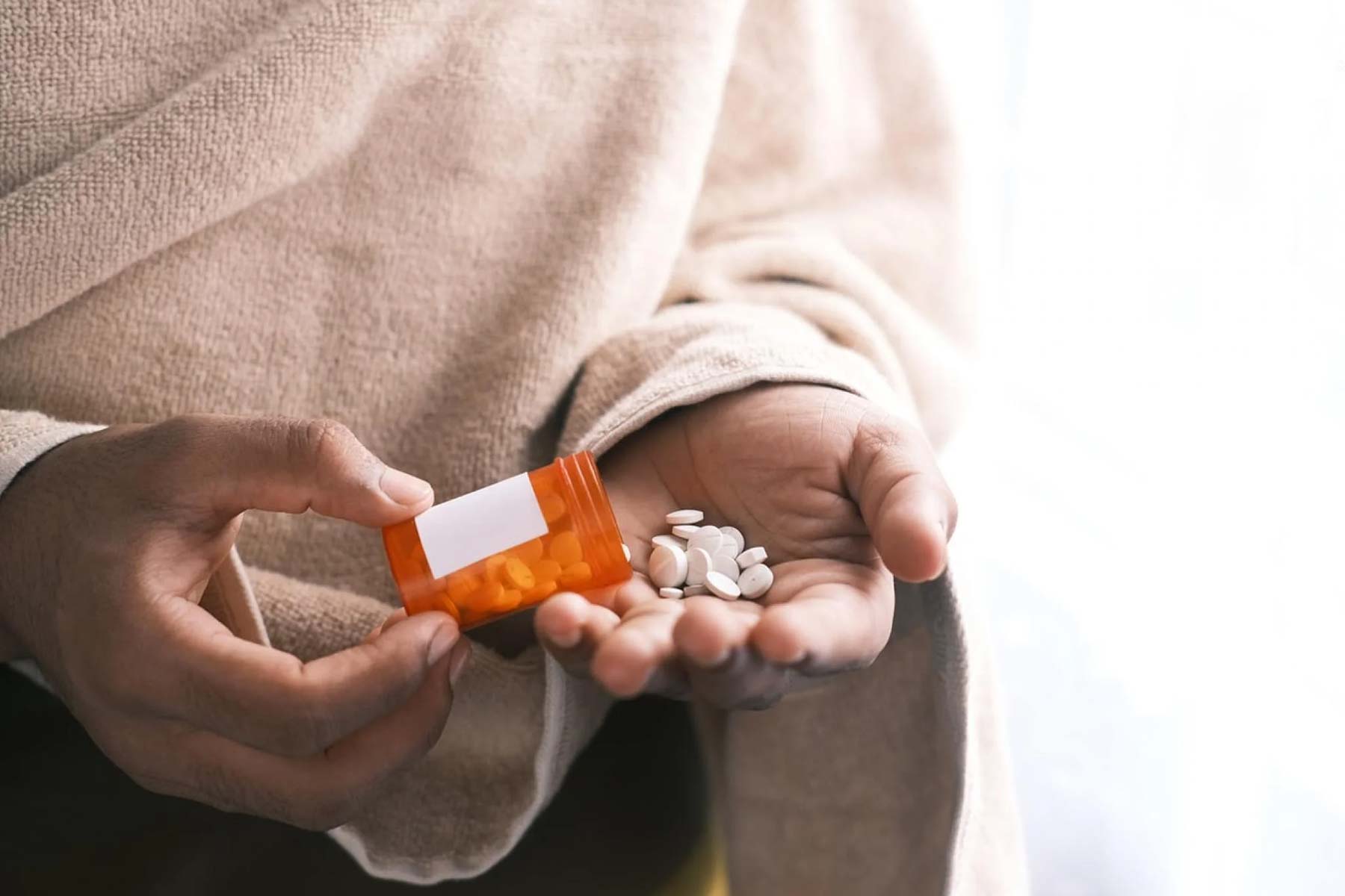 Person emptying medication into hand