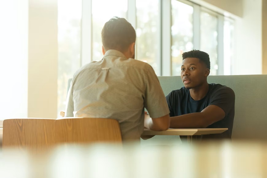 Two men sat at table having therapy session