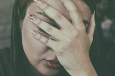 Close up of a woman with hand over her face